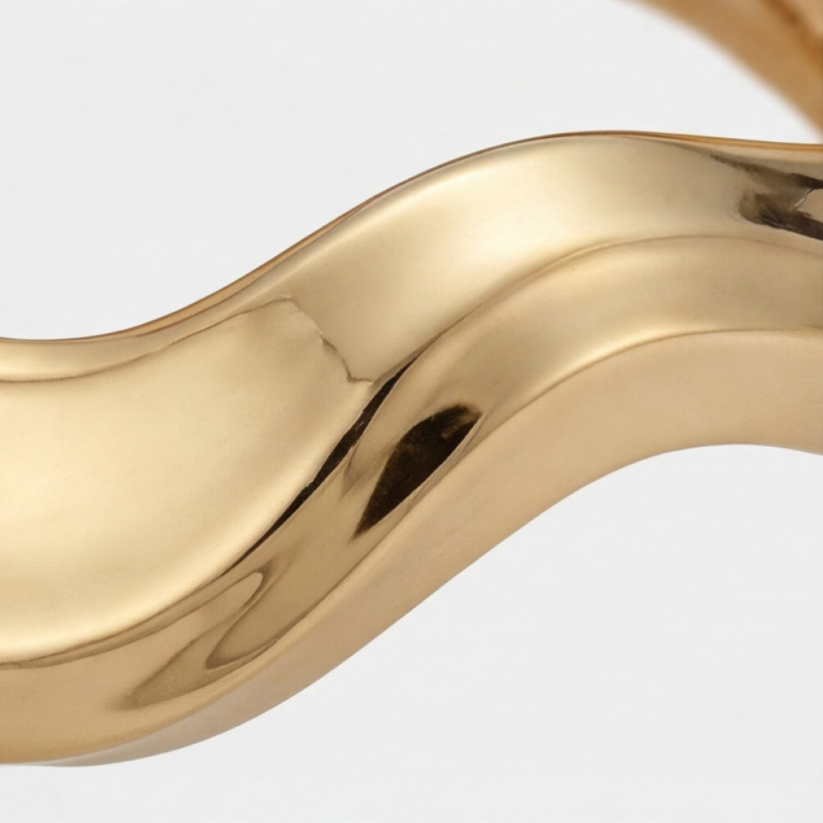 Gros plan sur la surface d’un bracelet manchette vague ton doré