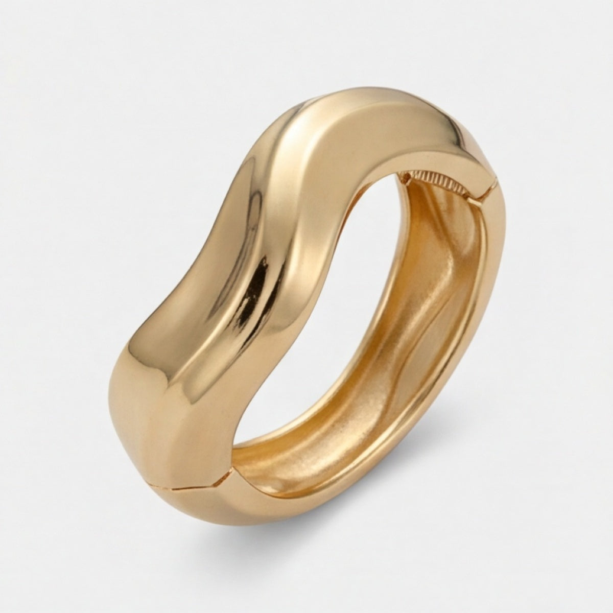 Vue de côté d’un bracelet manchette vague ton doré aux bords arrondis