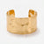 Front-facing detail of the wide gold-tone hammered open cuff bracelet