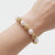 Perlenartiges Armband mit goldfarbenen Kugeln am Handgelenk getragen