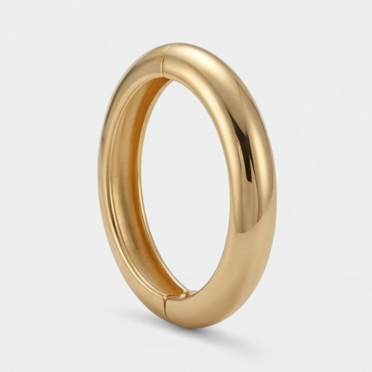 Seitenansicht eines glatten gerundeten goldfarbenen Armreifs