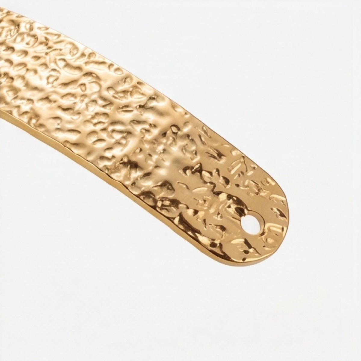 Close-up of the slim textured cuff bracelet end with small holes