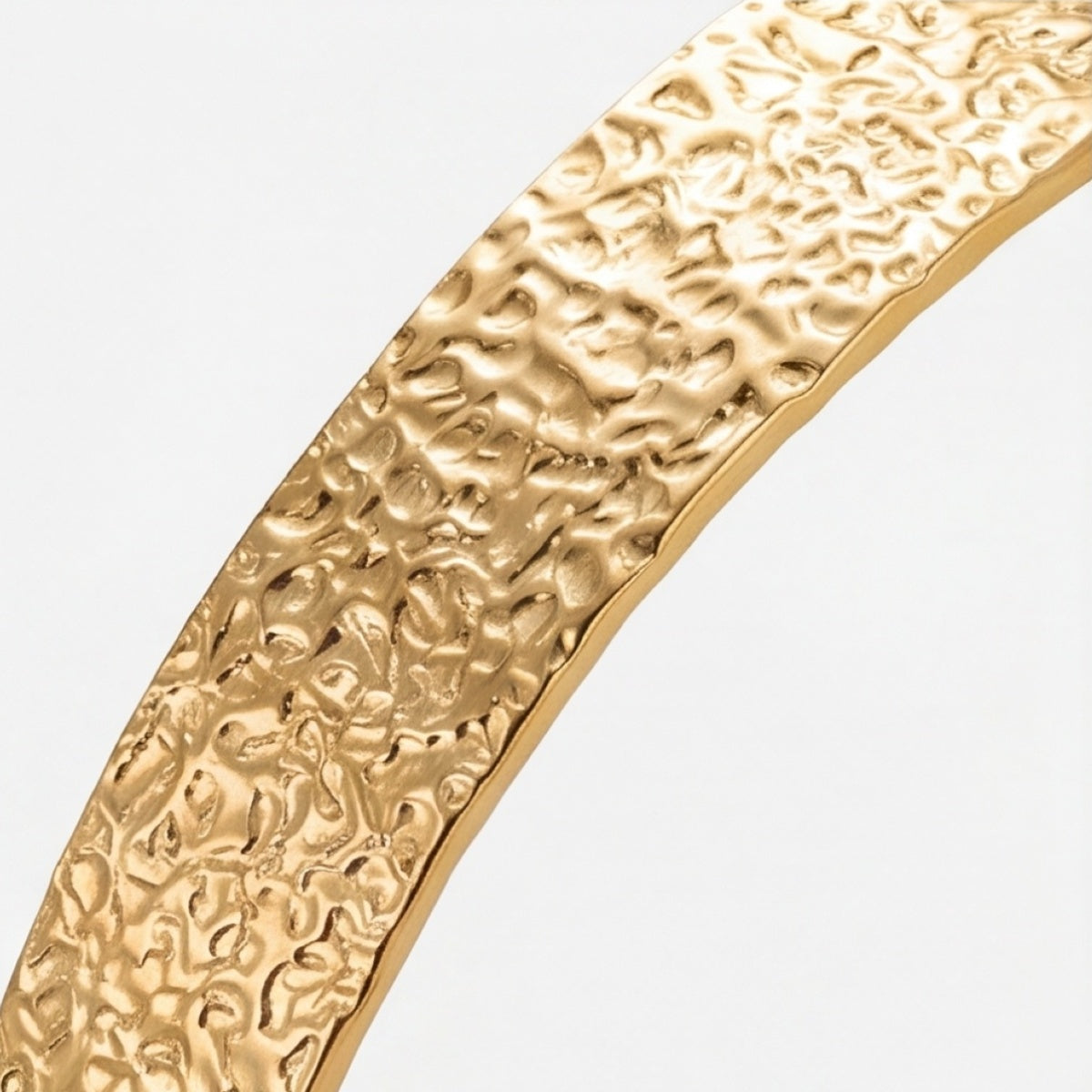 Close-up of the slim gold-tone textured cuff bracelet band
