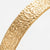 Close-up of the slim gold-tone textured cuff bracelet band