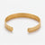 Slim gold-tone textured open cuff bracelet shown from above